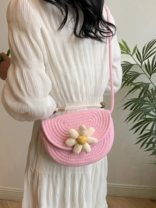 Pink woven saddle bag with daisy floral detail for beach vacations and summer style