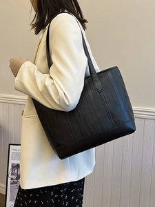 Minimalist black tote bag with vertical ripple texture for daily commute style