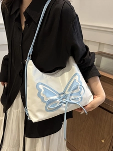 Bolso de hombro blanco y azul claro con gran lazo de mariposa y correa ajustable