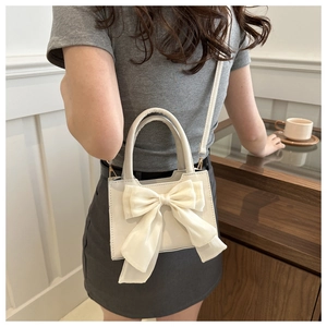 Detail of white mini handbag with large organza bow and adjustable crossbody strap