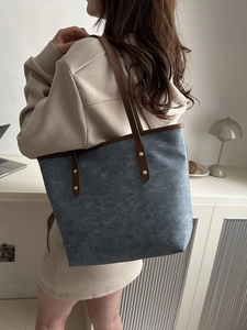 Grand sac cabas bleu-gris avec anses en cuir marron et détails de rivets dorés
