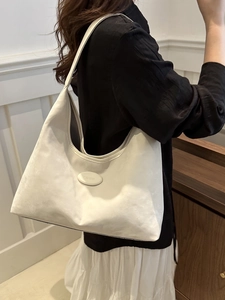 Chic beige matte leather large hobo bag being worn over the shoulder by a woman