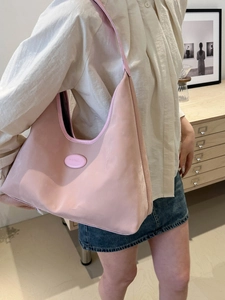 Pink hobo shoulder bag with smooth synthetic leather texture worn by a model