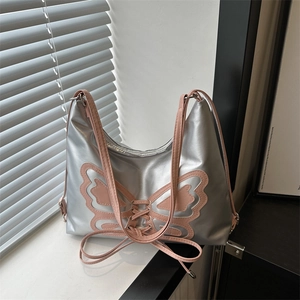 Y2K style silver crescent bucket bag with pink butterfly and lace-up details