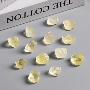 Natural yellow crystal raw stone fragments for handmade crafts on a grey background