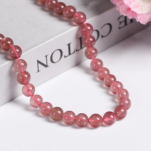 Natural pink strawberry quartz round beads necklace displayed on a white jewelry prop