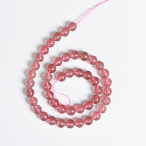 Natural pink strawberry quartz round beads for DIY jewelry making displayed in a spiral
