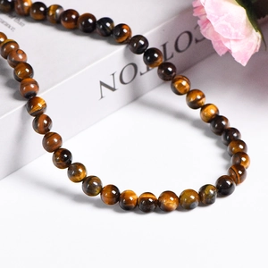 Natural yellow tiger eye gemstone beads showing golden sheen and polished round texture
