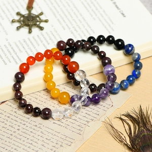 12 Sternzeichen Naturkristall-Armbandset mit Edelsteinen auf Vintage-Büchern präsentiert