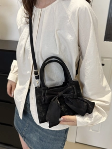 Elegante borsa nera da donna con grande fiocco decorativo e tracolla versatile per ogni look