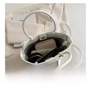 Top-down detail view of spacious beige bucket bag interior with phone and wallet