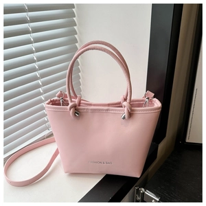 Close-up of pink bucket bag with silver clasp and FASHION & BAG lettering