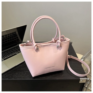 Detail of light pink faux leather tote bag with fine texture and adjustable shoulder strap