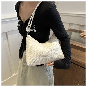 Gros plan sur un sac hobo blanc en cuir tressé avec des détails de texture et bandoulière nouée