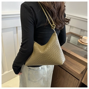 Detail of a green woven leather hobo bag showing texture and decorative knot strap