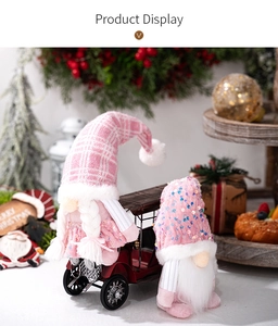 Pink Christmas gnomes with sequins and plaid hats displayed by a red vintage toy car