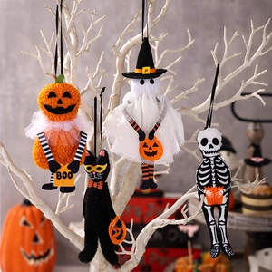 Dettaglio di ciondoli di peluche per Halloween con zucca e fantasma appesi a rami bianchi
