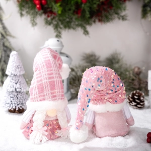 Pink Christmas gnomes with knit sequin hats on snowy ground with winter holiday decor