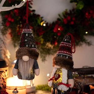 Nahaufnahme leuchtender Weihnachtswichtel mit Strickmützen und warmen LED-Lichtern