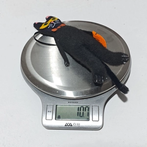 Dettaglio di un ciondolo a forma di gatto nero per Halloween da 10,7g su una bilancia