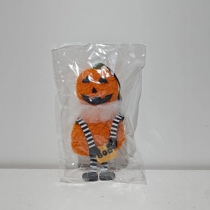 Dettaglio peluche zucca di Halloween con gambe lunghe a strisce e cartello Boo confezionato