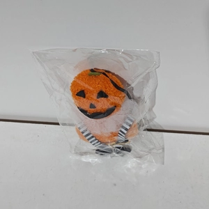 Dettaglio di un peluche a forma di zucca di Halloween in confezione protettiva