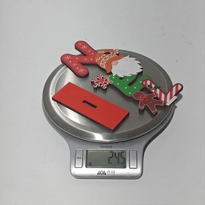 Christmas NOEL wooden centerpiece weight measurement showing 24.5g on a digital scale