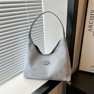Light blue matte textured large hobo shoulder bag with logo on modern minimalist backdrop
