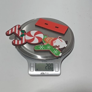 Wooden JOY Christmas sign with gnome and peppermint candy being weighed on a scale