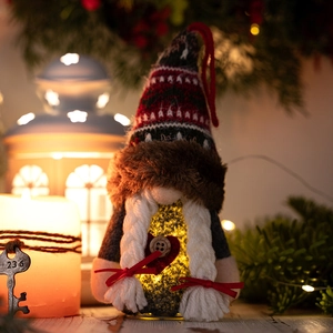 Nahaufnahme leuchtender Weihnachtszwerg mit Strickmütze und Herzdetail in festlicher Deko