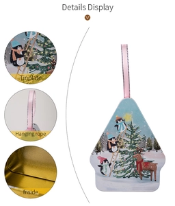 Detail display of Christmas tree tinplate candy box with festive penguin reindeer prints