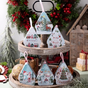 Detail of six Christmas tin gift boxes with holiday patterns on a rustic wooden tray
