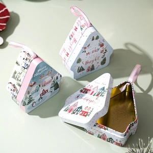 Three Christmas-themed house-shaped tin boxes with festive illustrations and pink ribbons