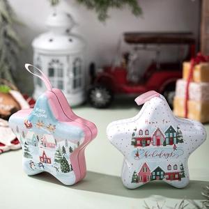 Star-shaped Christmas tin boxes with festive illustrations and hanging ropes on a table