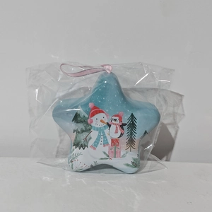 Detailed view of a star-shaped blue Christmas tin with snowman and penguin illustrations