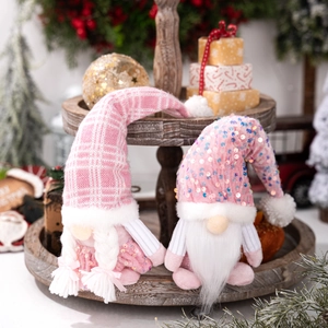 Gnomes de Noël à paillettes roses avec chapeaux tricotés sur plateau en bois rétro