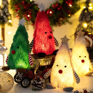 Close-up of lighted Christmas tree plush ornaments with star toppers and striped arms