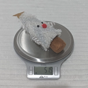 Detailed view of plush white Christmas tree ornament weighing 51.9g on a kitchen scale