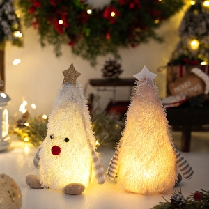 Close-up of plush glowing Christmas tree figurines with soft fur and warm LED lights