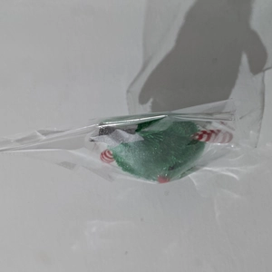 Detail of green plush Christmas tree desktop ornament in protective clear packaging