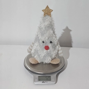 Detail shot of a plush Christmas tree doll on a digital scale weighing 72.7 grams