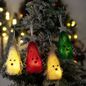 Detail of light-up plush Christmas tree ornaments hanging with warm LED glow