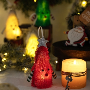 Macro view of glowing red conical Christmas tree ornament with LED light and star