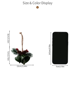 Size comparison of green Christmas bell with pine needles and berries next to a phone