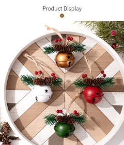Set of four colorful Christmas bells with pine needles, berries, and pinecones in a wooden tray