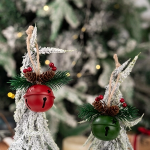 Close-up of red and green metal Christmas bells with pine needles and berries