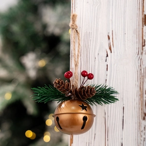 Detail of vintage bronze star-cutout Christmas bell with pine needles and red berries