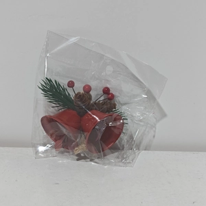 Christmas ornament with red metal bells, pine needles and pine cones in clear packaging