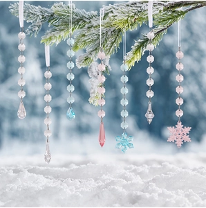 Detailed view of clear acrylic snowflake and icicle pendants hanging on snowy branches