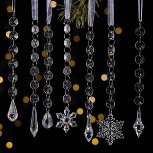 Detail of clear acrylic Christmas icicle and snowflake pendants with elegant bokeh background